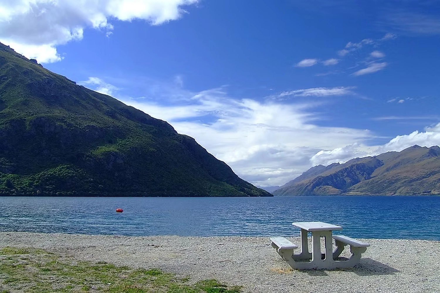 Ein gedeckter Tisch an einem See vor Bergen